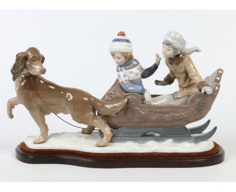 A large Lladro figure group on plinth. Formed as a pair of figures in a sleigh being pulled by a dog. Printed mark, 48cm long