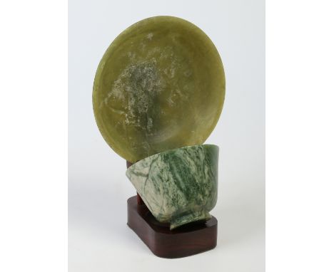 A Chinese jade coloured soapstone tea bowl and saucer on stand, saucer 14cm diameter. Condition Report. To be used as a guide