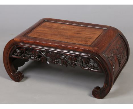 A 19th century Chinese carved hardwood kang table. With open fret carved vine work frieze, further vine carvings to the side 