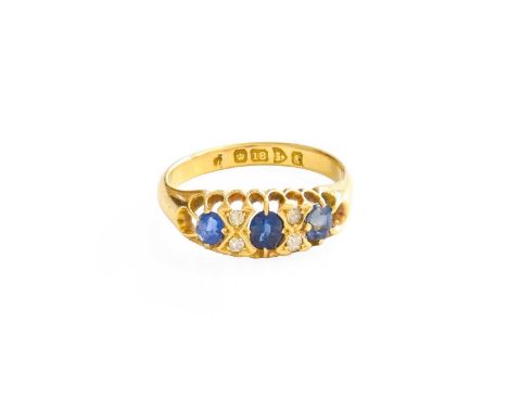 An 18 Carat Gold Sapphire and Diamond Ring, three oval cut sapphires spaced by pairs of old cut diamonds, in yellow claw sett