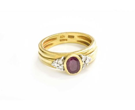 An 18 Carat Gold Ruby and Diamond Ring, the oval cut ruby in a yellow rubbed over setting, flanked by trios of round brillian
