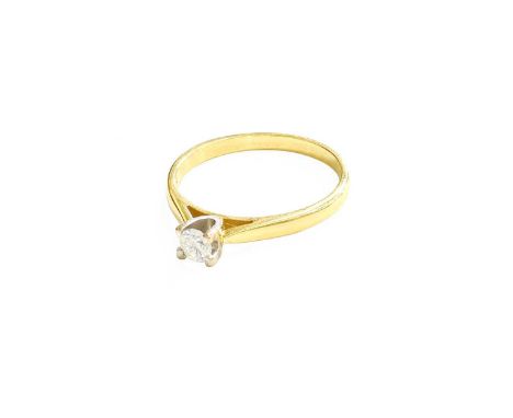 An 18 Carat Gold Diamond Solitaire Ring, the round brilliant cut diamond in a white four claw setting, to a yellow tapered sh