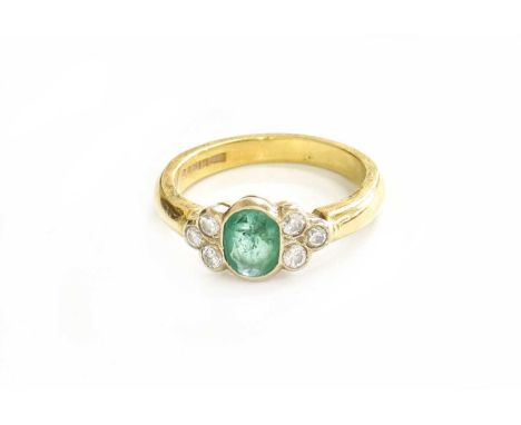 An 18 Carat Gold Emerald and Diamond Ring, the oval cut emerald flanked by trios of round brilliant cut diamonds, in white ru