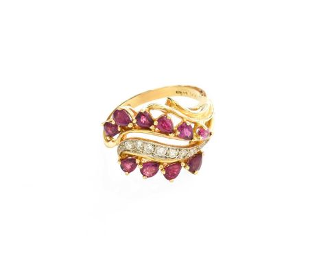 A 14 Carat Gold Ruby and Diamond Ring, a row of round brilliant cut diamonds in white claw and millegrain settings, flanked b