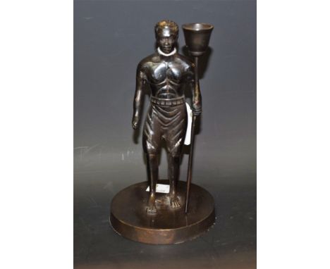 A dark patinated figural candlestick, as a tribesman
