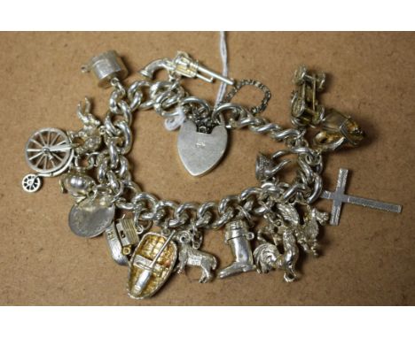 A silver charm bracelet, heart shaped locket; charms to include Noah's Arc, vintage car, Welsh dragon, penny farthing, etc.; 