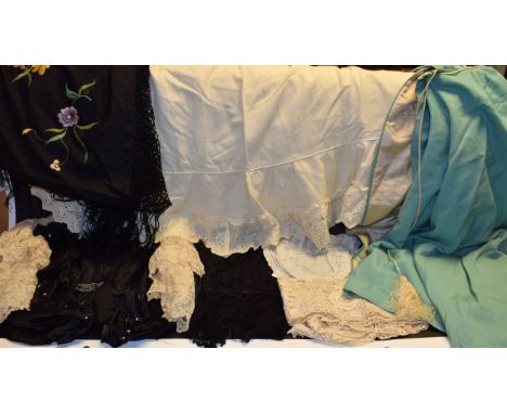 A large black silk shawl, embroidered multi-coloured flowers; a late 19th, early 20th Century cape, light turquoise, tasseled