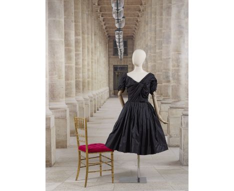 Jacques Fath, collection Haute Couture, circa 1953. Robe de cocktail en soie noire.Haut à décolleté en pointe et à effet cach