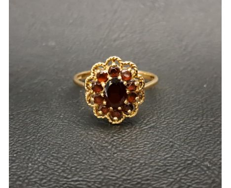 GARNET CLUSTER RINGthe central oval cut garnet approximately 0.8cts in ten garnet surround, on nine carat gold shank with pie