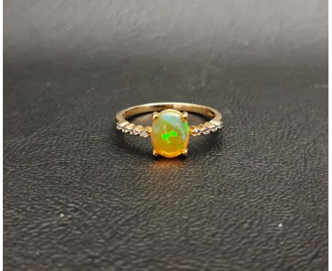 ETHIOPIAN OPAL AND DIAMOND RINGthe central oval cabochon opal measuring 8.7mm x 6.8mm, flanked by diamond set shoulders, on n