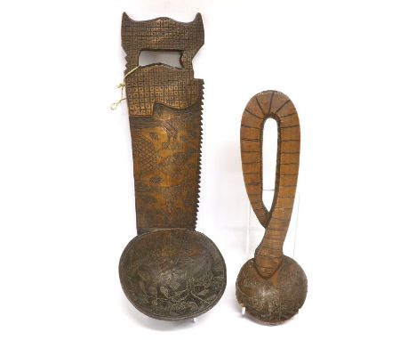 An Early 20th Century Asante Ceremonial Carved Wood Yam Ladle, Ghana, with deep bowl, the handle carved in the form of a saw,