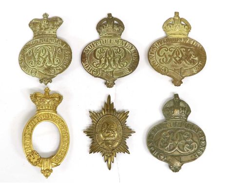 The Grenadier Guards - four Valise Badges, in brass, one Victorian, one Edwardian now backed with a lead panel, and two Georg