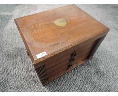 A Walker &amp; Hall oak cased canteen of cutlery, of rectangular form, the hinged top with central inlaid brass shield form c