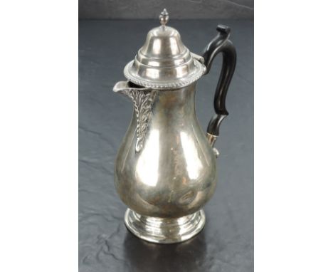An Edward VII silver hot water pot, hading a moulded and domed finial topped cover with gadrooned rim over the baluster body,