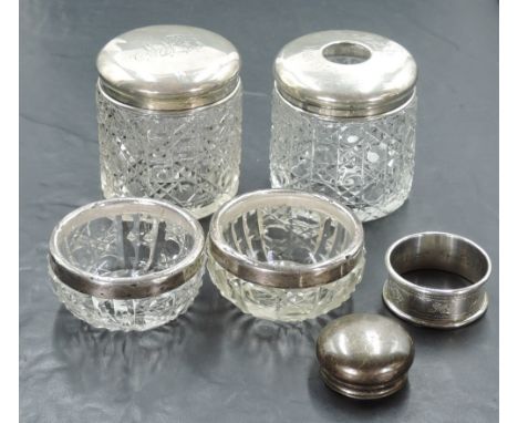 A group of silver mounted glass wares, a pair of silver rimmed cut-glass salts, a pair of silver topped dressing table jars, 