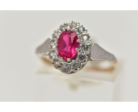 A 9CT GOLD CLUSTER RING, of an oval form, centring on an oval cut synthetic ruby, in a surround of colourless spinels, tapere