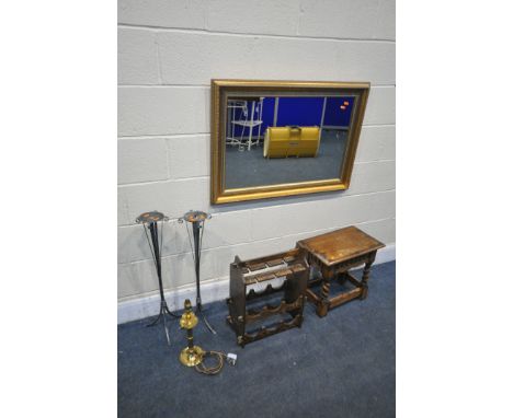 A GILT FRAMED WALL MIRROR, 91cm x 65cm, a carved oak occasional table, two metal candle stand, a wine rack/glass holder, and 