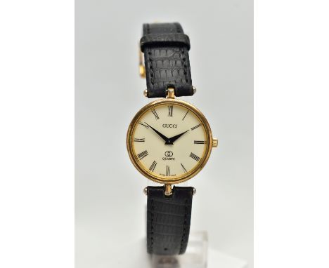 A 'GUCCI QUARTZ' WRISTWATCH, round cream dial signed 'Gucci, Quartz', red and green band around the yellow metal case, Gucci 