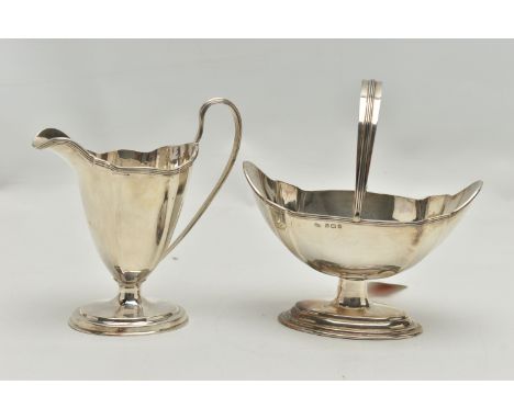 AN EDWARDIAN MATCHED MILK JUG AND SWING HANDLED SUGAR BASKET OF PANELLED OVAL FORM, reeded rims, short pedestal to a stepped 