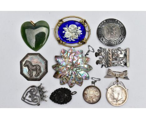 AN ASSORTMENT OF PENDANTS AND BROOCHES, the first a heart shaped nephrite jade pendant, fitted with a yellow metal bail, a Vi