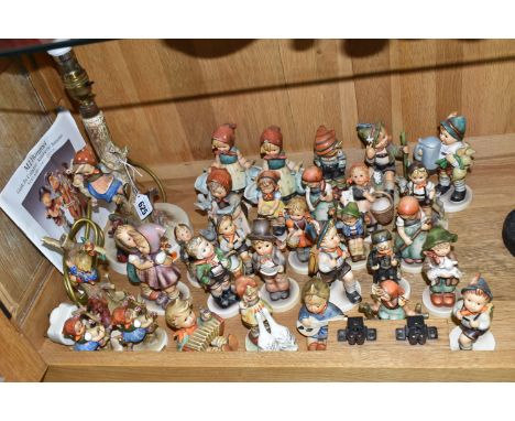 A COLLECTION OF THIRTY ONE PIECES OF GOEBEL HUMMEL AND A RELATED BOOKLET, including an 'Out of Danger' table lamp, chimney sw