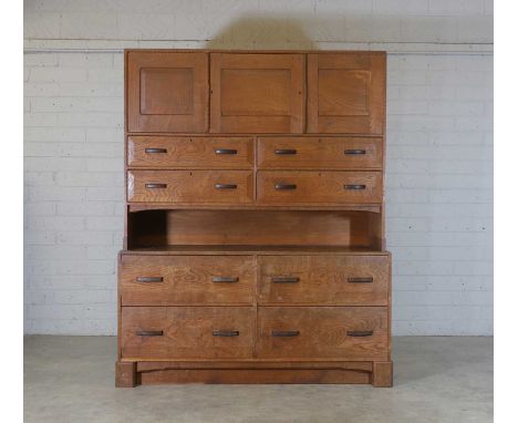 Stanley Webb Davies (1894-1978), an oak, chestnut and ebony cabinet, dated 1942, with three panelled cupboards over four draw