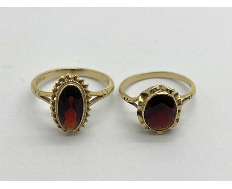 A 9ct Gold Vintage Style Garnet Ring, the elongated stone, to rubover setting, between stepped textured frame and bifurcated 