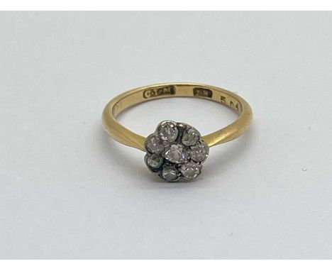 A Dainty Diamond Cluster Ring, set with old and single cut stones, stamped "18" (finger size K1/2).
