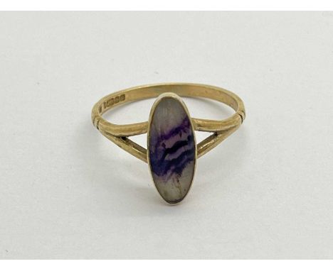 A 9ct Gold Dainty Blue John Ring, the rubover set elongated stone to bifurcated shoulders and ridged uniform band, (finger si