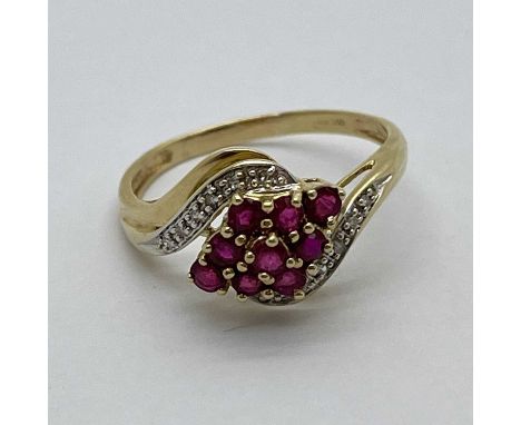 A Diamond and Ruby Set Ring, of crossover design, round set stones, claw set throughout, to reeded shoulders and tapered band