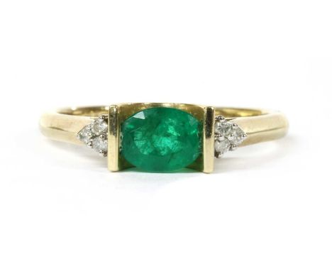 A 9ct gold emerald and diamond ring, an oval mixed cut emerald, approximately 7 x 5mm, end set with a trefoil of brilliant cu