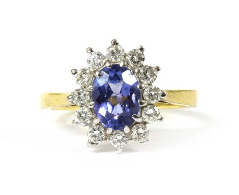 An 18ct gold tanzanite and diamond cluster ring, an oval mixed cut tanzanite, 7.84 x 5.95 x 3.96mm, with surround of brillian