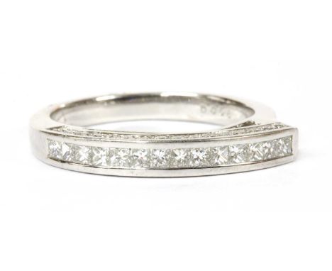 A white gold diamond ring, a row of princess cut diamonds, channel set, to guards grain set with rows of brilliant cut diamon