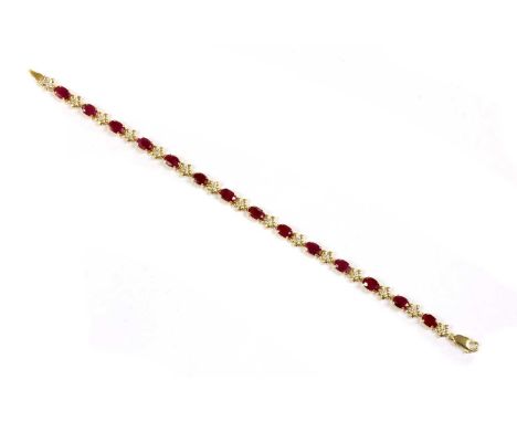 A 9ct gold ruby and diamond bracelet, oval mixed cut rubies, claw set to articulated collets, joined by floral links each cla