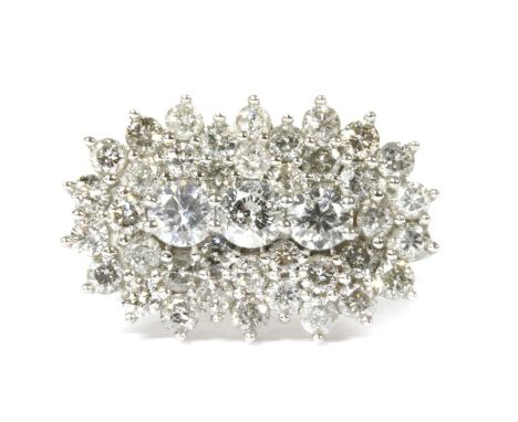 A white gold diamond cluster ring, a row of brilliant cut diamonds, claw set, to two row surround of smaller brilliant cut di