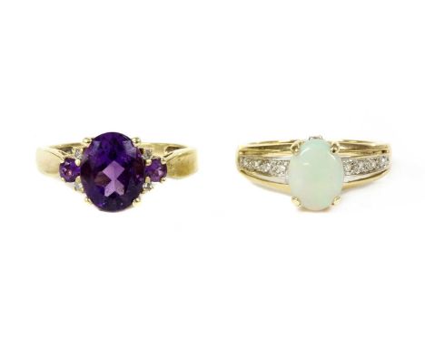 A 9ct gold amethyst and diamond ring, an oval mixed cut amethyst, approximately 10 x 8mm, flanked either side by a circular m