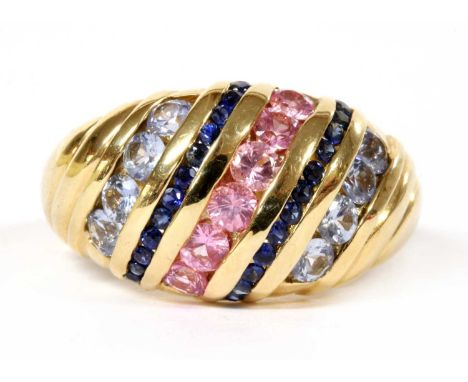A 9ct gold varicoloured sapphire bombé ring, diagonal rows of circular mixed cut pink sapphires, sapphires and pale blue sapp