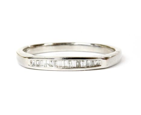 A white gold diamond half eternity ring, a row of baguette cut diamonds, channel set, to a plain polished shank, marked 9k, t