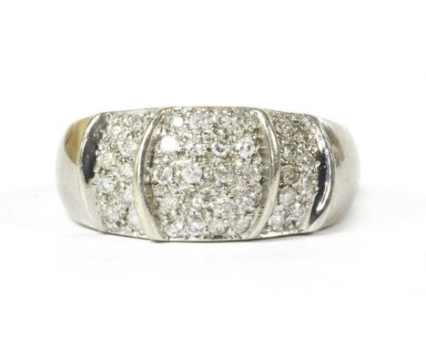 A 9ct white gold diamond ring, the slighty domed, tapered head pavé set with brilliant cut diamonds between slightly raised c