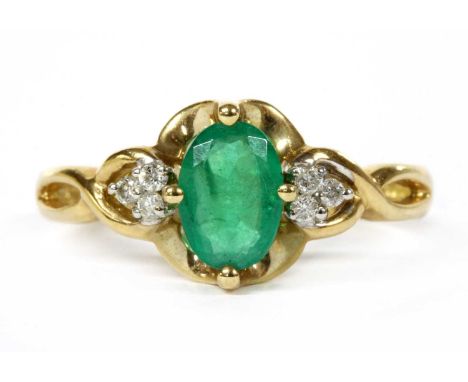 A 9ct gold emerald and diamond ring, an oval mixed cut emerald, approximately 7 x 5mm, claw set at the cardinal points, with 