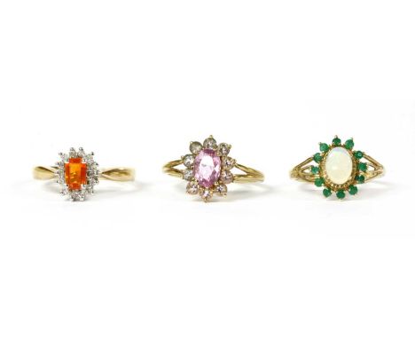 Three 9ct gold rings, to include a fire opal and diamond cluster ring, with an emerald cut fire opal to surround of brilliant