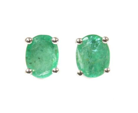 A pair of white gold single stone emerald stud earrings, an oval mixed cut emerald, approximately 5 x 4mm, claw set to post a