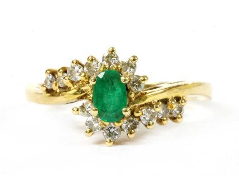 An 18ct gold emerald and diamond crossover cluster ring, Birmingham 1990, 3.22g.Finger size MCondition report: Slightly dirty