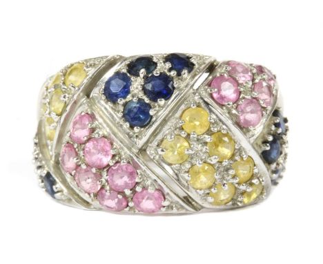 A 9ct white gold varicoloured sapphire ring, with circular mixed cut blue, yellow and pink sapphires, grain set to the plaite