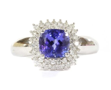 A 9ct white gold tanzanite and diamond double halo cluster ring, a cushion cut tanzanite, 6.89 x 7.22 x 5.56mm, claw set to t
