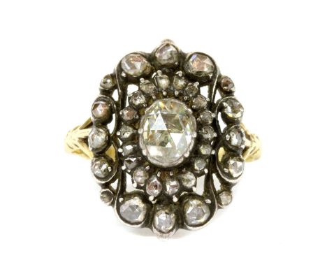 A gold and silver diamond oval cluster ring, a rose cut diamond in clawed collet to the centre, to surround of smaller rose c