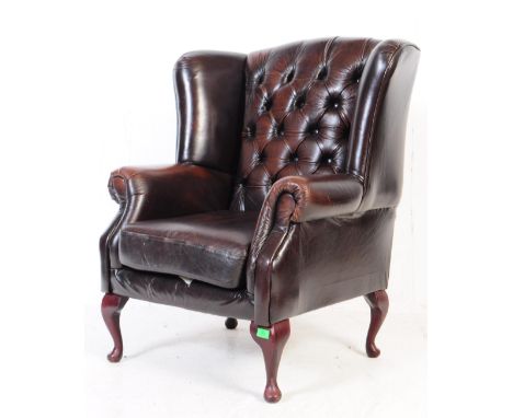 A 20th century brown / tan leather chesterfield wingback armchair. Having button back cushioned back rest, flanked by wings. 