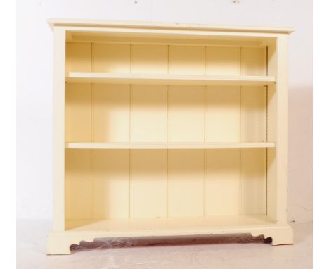 A vintage 20th century oak painted bookcase. Rectangular form with flared top series of shelves raised on a plinth base. Meas