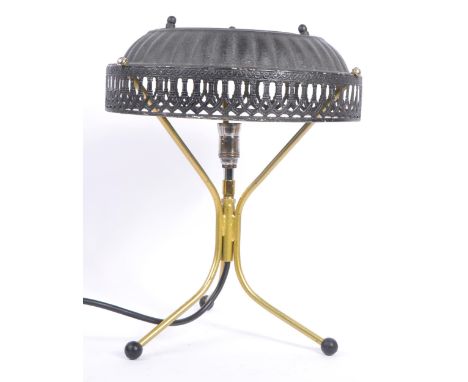 A late 20th century brass tripod table lamp with pressed tin lampshade with pierced decoration shade surround, raised on thre