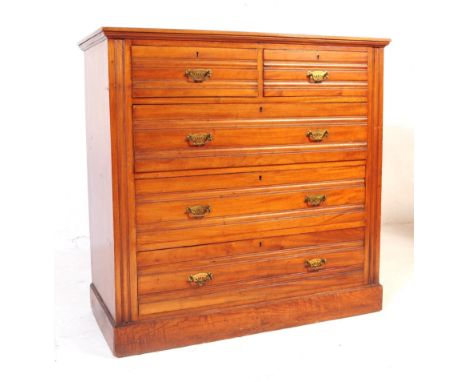 An early 20th century Edwardian walnut and satinwood chest of drawers. Rectangular form with flared top with a bank of two ov